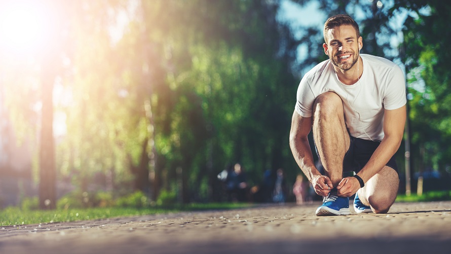 Mann bindet sich die Schnürsenkel zum Joggen Mann bindet sich die Schnürsenkel zum Joggen